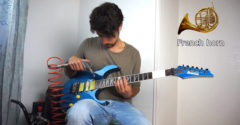 A férfi különböző hangszereket utánoz a gitárjával. Kompresszort, zoknit vagy bankjegyet használ