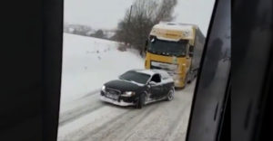 A kis Audi elvontatott egy kamiont a hófödte emelkedőn. (Lengyelország)